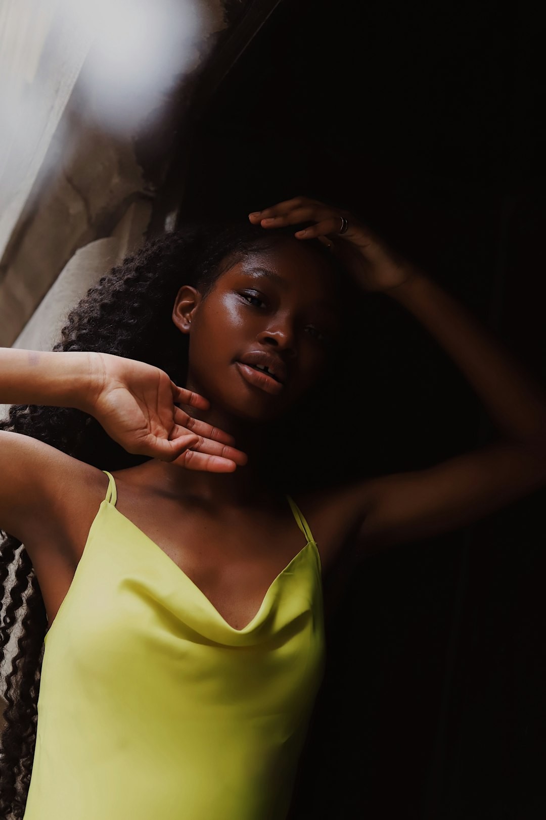 woman in yellow tank top lying on bed